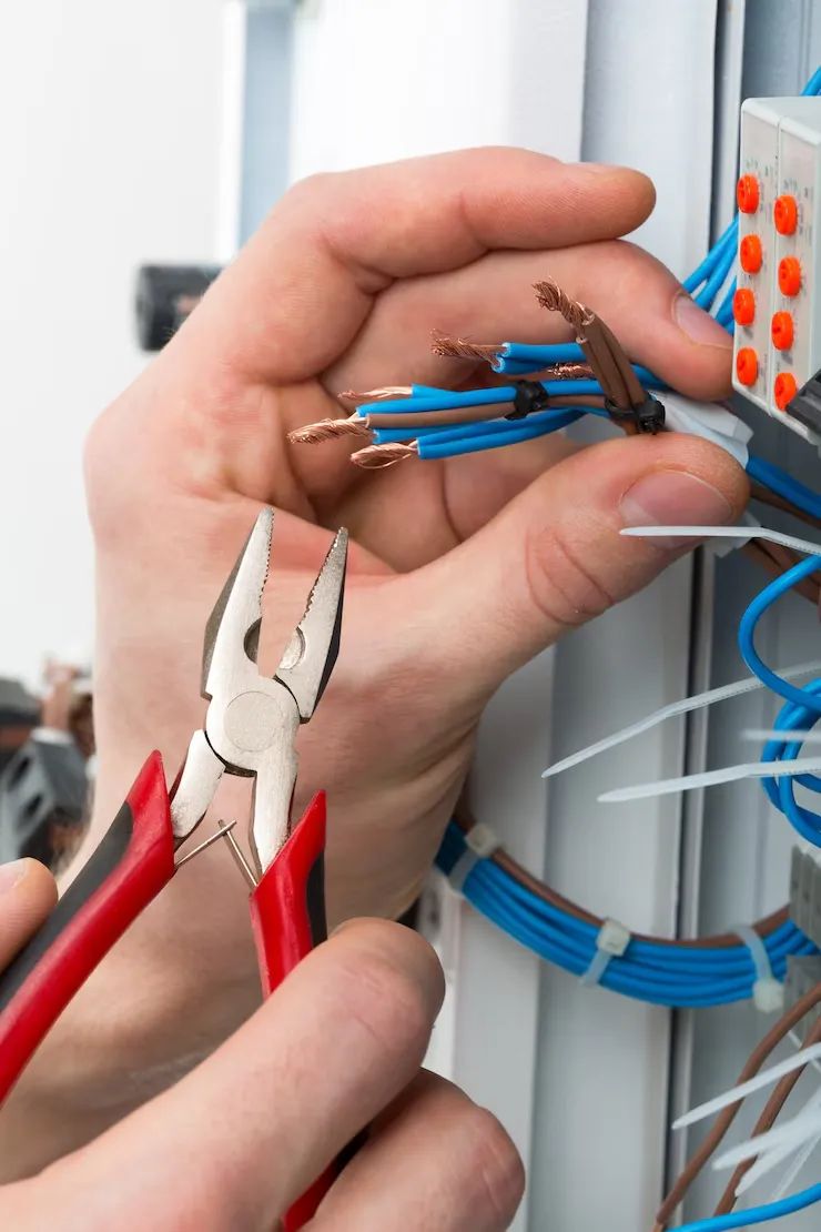 Técnico ajustando un panel eléctrico en un centro de trabajo para mejorar el rendimiento energético.